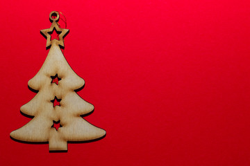 Fototapeta na wymiar Christmas wooden toy Christmas tree on a red background