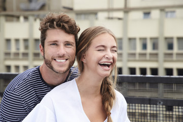 Laughing young couple in city, portrait
