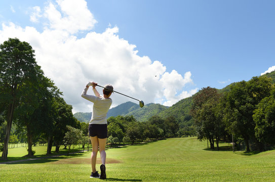  Young Asian woman playing golf on a beautiful natural golf course
