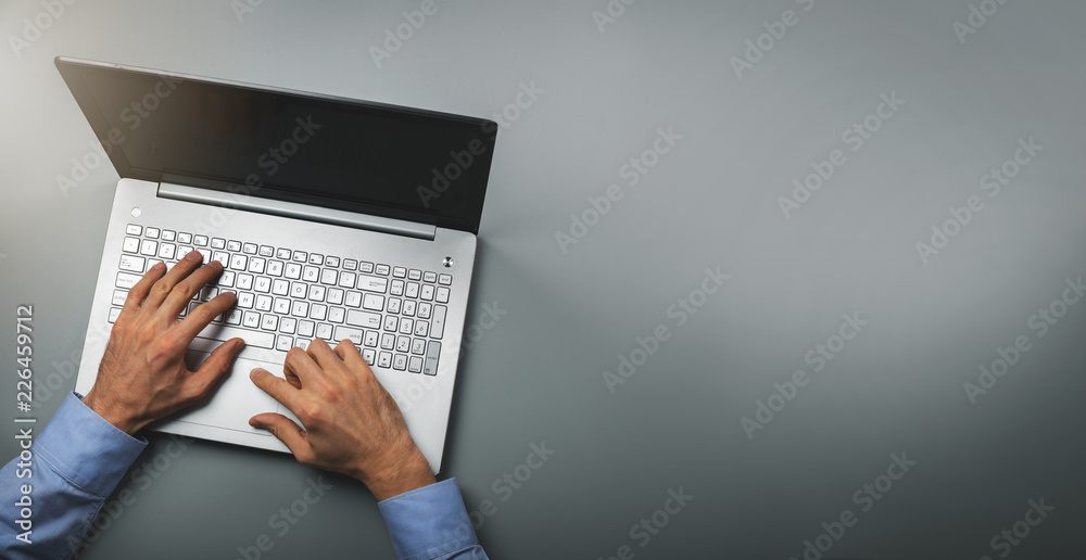 Wall mural man typing on laptop computer. top view copy space