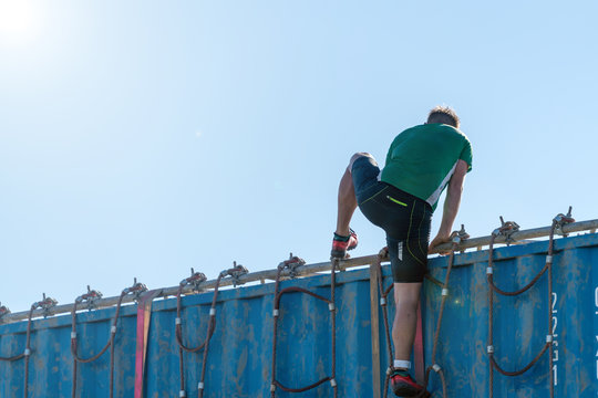 Athlete climbing over a container at an obstacle course race