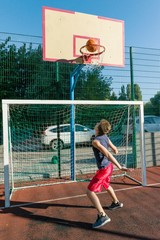 Teenager boy street basketball player on the city basketball court