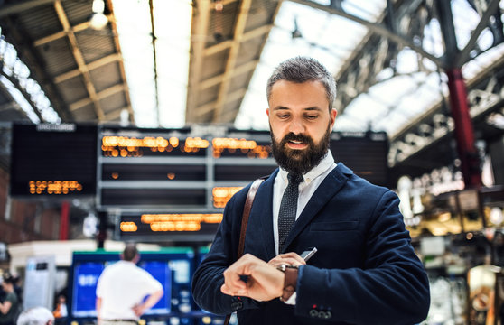 Businessman on the trian station in London, checking the time.