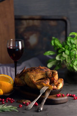 Grilled chicken with potatoes and cranberries on a wooden background.
