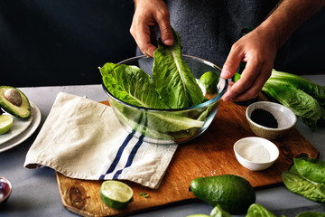 Man cooking green detox salad romaine lettuce Healthy food