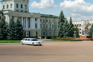Luxury white wedding limousine in Khmelnitsky on central square near the town council.