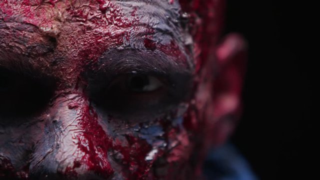 Zombie Maniac is scary of his teeth trying to bite the dark background of darkness