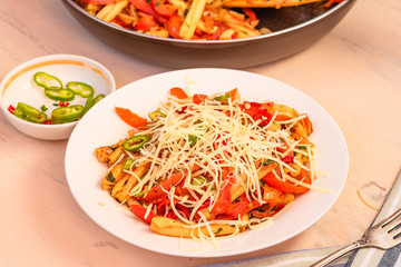 Italian food - Pasta with red pepper and parmesan on a white plate on a rustic light table