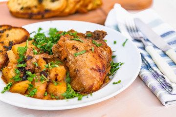 Healthy rustic food - stew chicken with potatoes in tomato sauce on a white plate, close-up