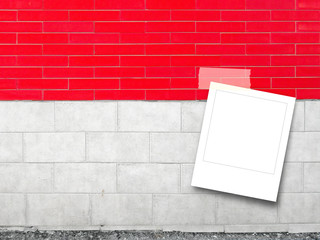 Blank square instant photo frame on red and white brick wall background