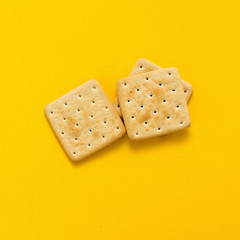 Tasty cookies biscuits on yellow colored background, top view