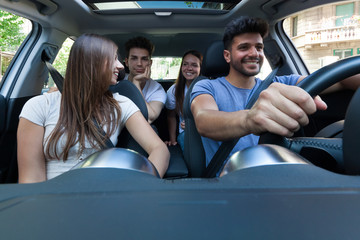 Group of happy friends on a car