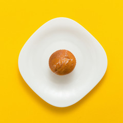 Freshly baked butter croissant on yellow colored background, top view