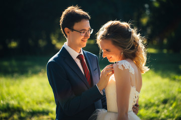 bride and groom embracing on nature background