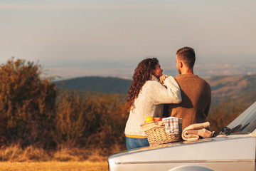 Beautiful young couple enjoying picnic time on the sunset.