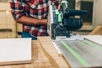 close up of carpenter sawing a wood plank