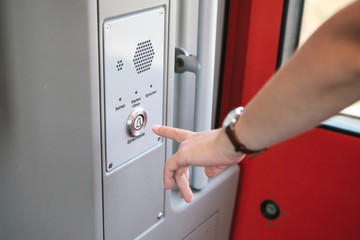 The person presses the button to call and talk with the support service of the train or subway. The...