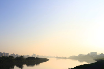 A view of a calm and quiet river that shines with tilted sunshine