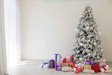 the Interior of the white room with a Christmas tree and Christmas gifts