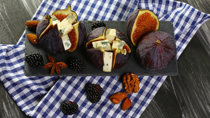 Gourmet appetizer of figs with dorblyu cheese, walnuts and honey on a shale board, traditional Turkish dessert, Seasonal harvest crop local produce concept. top view