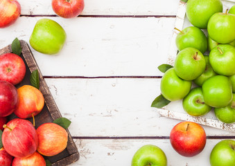 Fresh organic red and green apples in vintage box on wooden background. Top view