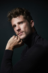 Handsome man in studio with hand on chin