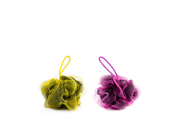 Two different color yellow and pink mesh net sponges isolated on white. Body wash background concept a lot of empty room for text and design.