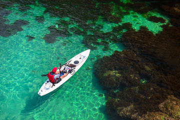Fisherman catches a fish on a fishing kayak view from above.