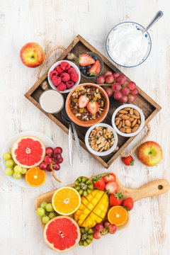 Above view of paleo grain free nut and fruit granola served with fruits and berries, nut milk, top view, vertical, selective focus