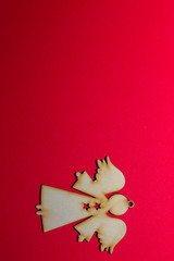 Christmas wooden toy angel on a red background
