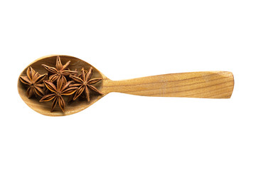 star anise in wooden spoon isolated on white background. spice for cooking food, top view.