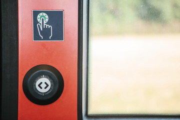 Close-up. The exit door of the train with a button to automatically open the door on demand when...