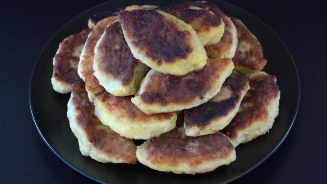 Potato cakes, ukrainian name potato zrazy, stuffed mushrooms or meat or cheese with herbs cream are fried in vegetable oil on black background, close up, rotates. Traditional Ukrainian cuisine