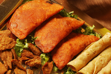 Saucer with Mexican food such as chicken tacos, empanadas, and sopes. Mexican street food, called antojitos (literally "little cravings"), is prepared at small traditional markets in Mexico.