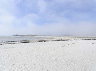 Mist rolling in from the sea across the white sands of Plage Sainte-Marguerite near Landeda in Brittany.