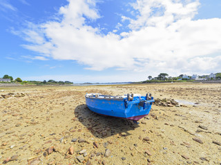 Small fishing boat beached in Kermengi harbour at low tide.
