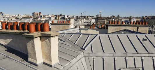 The roofs of Paris and its chimneys under a clouds sky