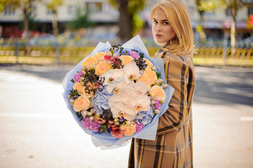 Girl holding a beautiful bouquet of different flowers