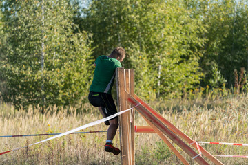 Athlete climbing over a wooden wall at an obstacle course race