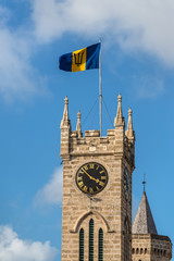 Clock tower of the Parliament Building, Bridgetown in Barbados, West Indies, Caribbean, Lesser Antilles, Central America. Flag of Barbados at the top.