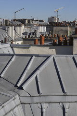The roofs of Paris and its chimneys under a clouds sky