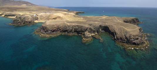 Vista aerea delle coste frastagliate e delle spiagge di Lanzarote, Spagna, Canarie. Strade e sentieri sterrati. Bagnanti in spiaggia. Spiaggia di Papagayo