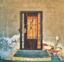 Walled door entry of abandoned house. Broken iron bars