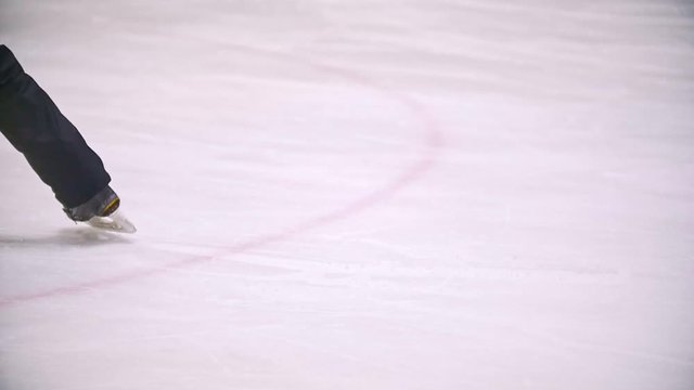 Hockey player brakes on the ice hockey field scattering ice particles