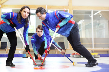 Curling. Zawodnicy grają w curling na torze curlingowym. - obrazy, fototapety, plakaty