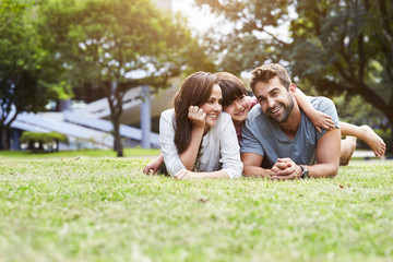 Fototapeta premium Smiling family lying together in park
