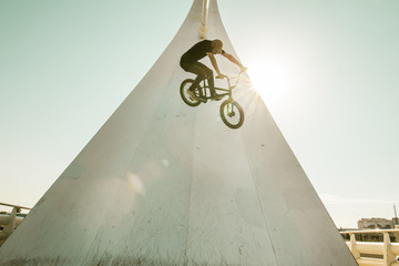 Young man with a bmx bike riding down the street