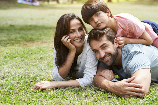 Smiling family relaxing together in park, portrait