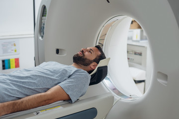 Patient Lying on the CT Scanner Bed - obrazy, fototapety, plakaty