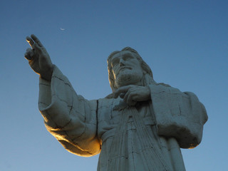 Fototapeta premium Christ statue (Cristo de La Misericordia) and the moon in San Juan del Sur, Nicaragua